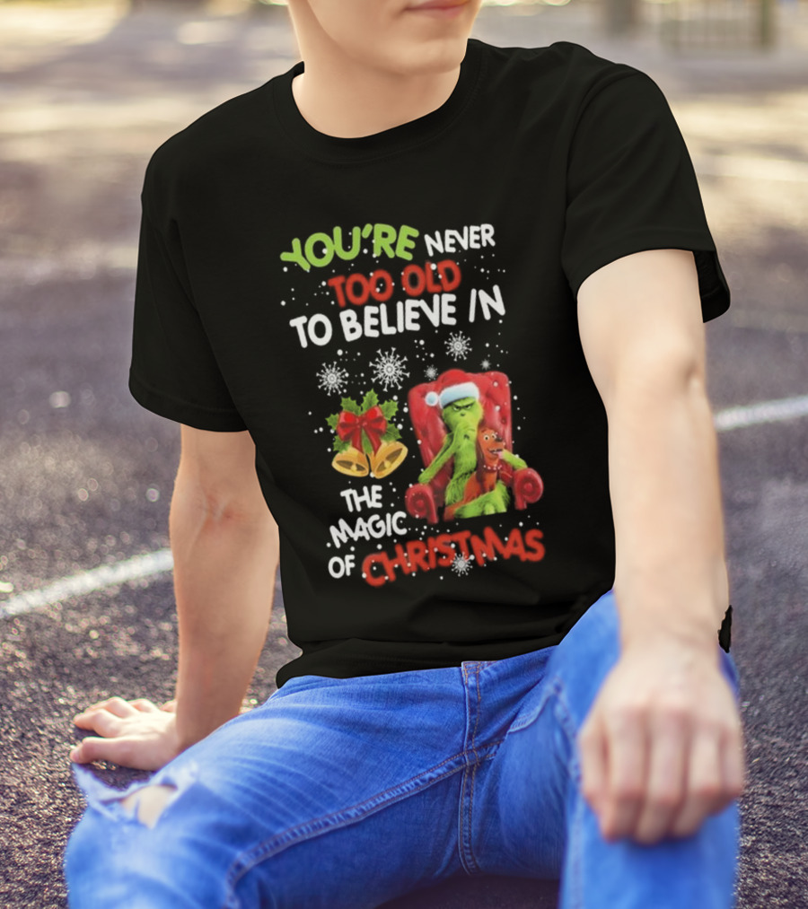 YOU'RE NEVER TOO OLD TO BELIEVE IN THE MAGIC OF CHRISTMAS GRINCH WITH MAX SITTING IN CHAIR SNOWFLAKES HOLIDAY BELLS AND BOW T-Shirt